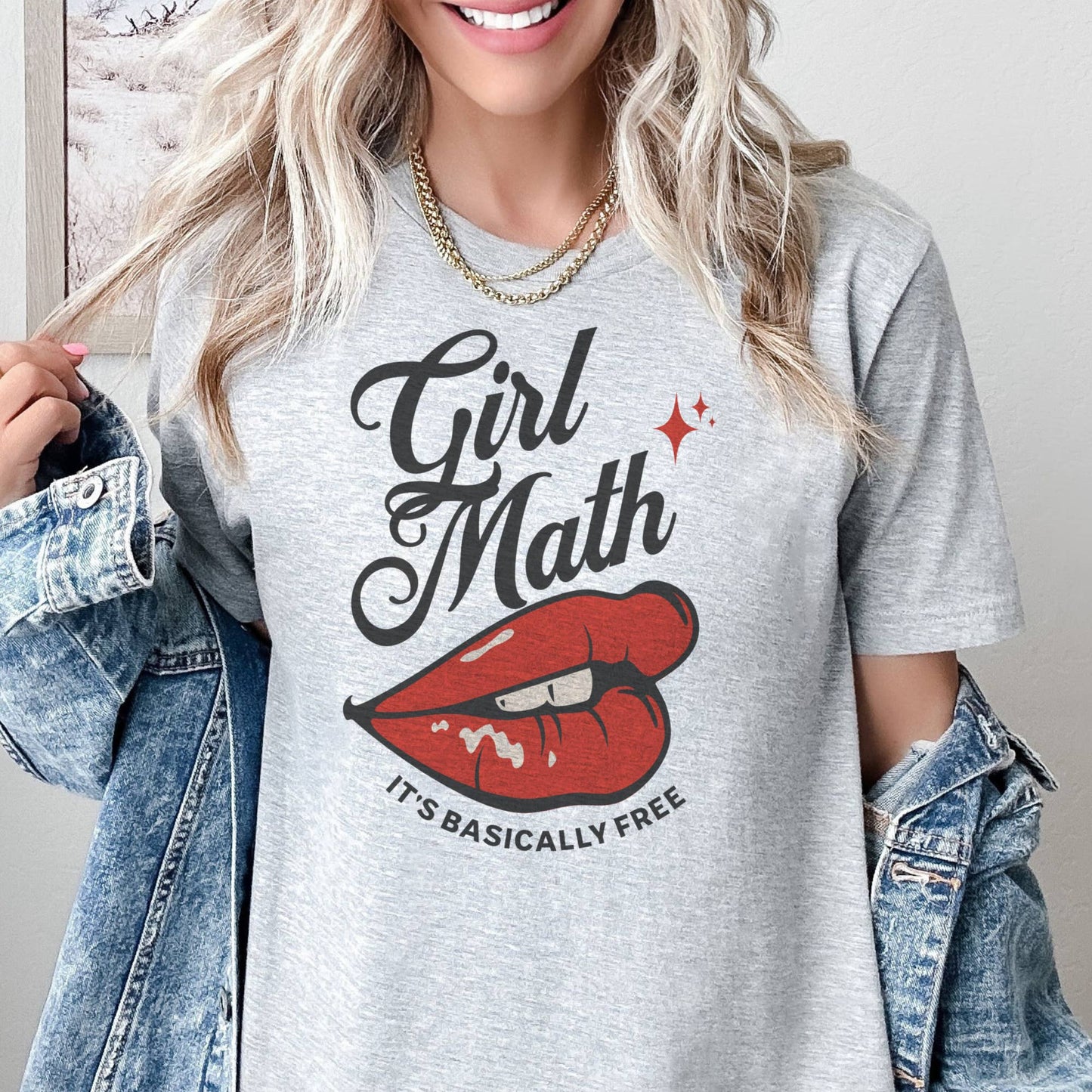 A woman wearing a gray t-shirt with the text 'Girl Math It's Basically Free' and a graphic of red lips.