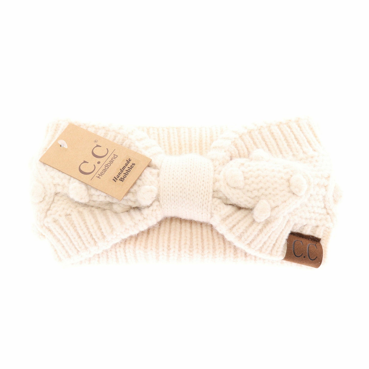 Cream-colored knitted headband with a bow on a white background, featuring a C.C label.
