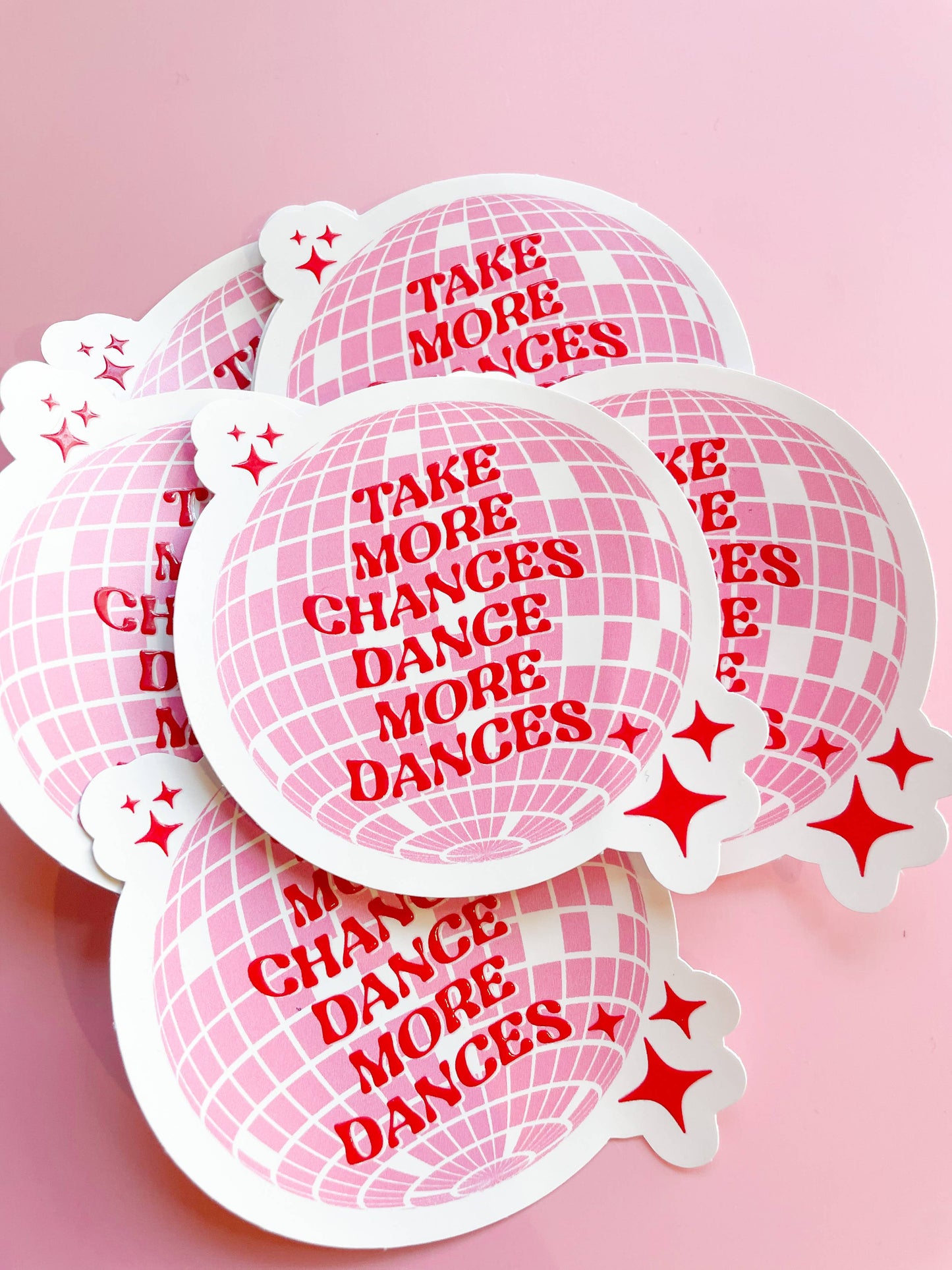 A collection of round pink stickers with text and star patterns on a pink background.