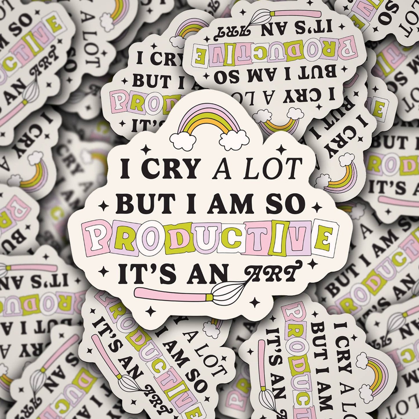 A vinyl decal with the phrase 'I cry a lot but I am so productive it's an art' with rainbow colors and decorative elements.