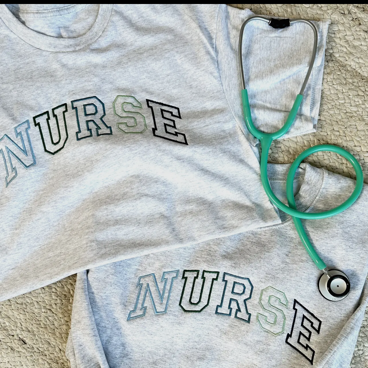 Gray 'NURSE' shirt with a green stethoscope on a textured surface