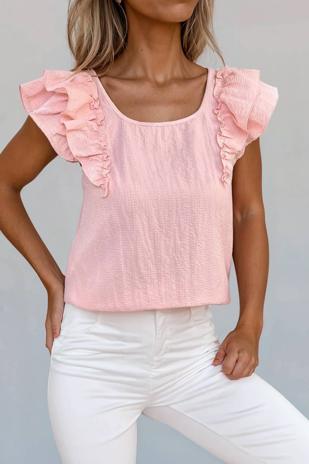 A pink blouse with ruffled sleeves and a bow knot at the back neckline, displayed on a model.