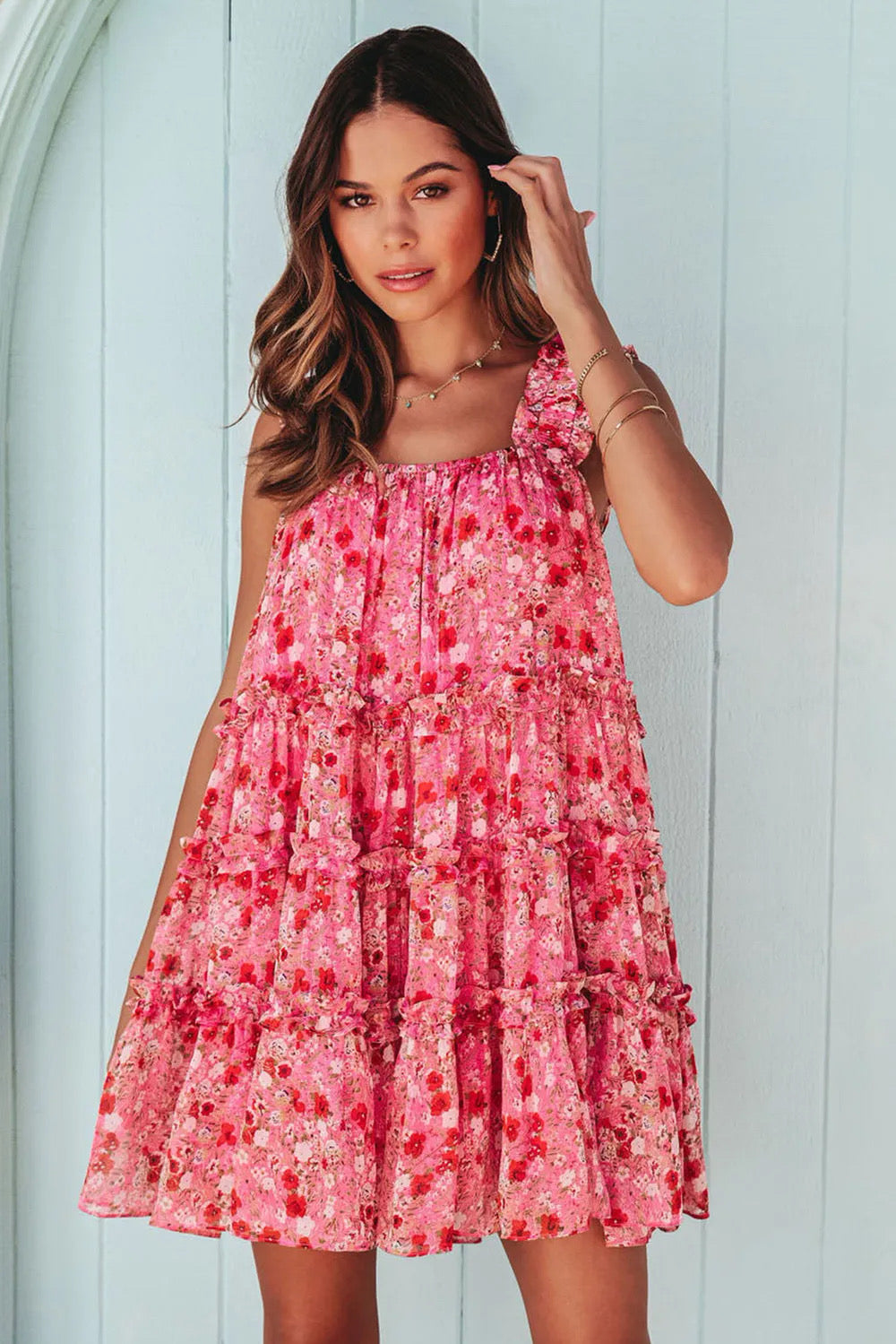This image features a vibrant, wide strap floral mini dress. The dress is adorned with a lively pink floral pattern, creating a cheerful and youthful look.