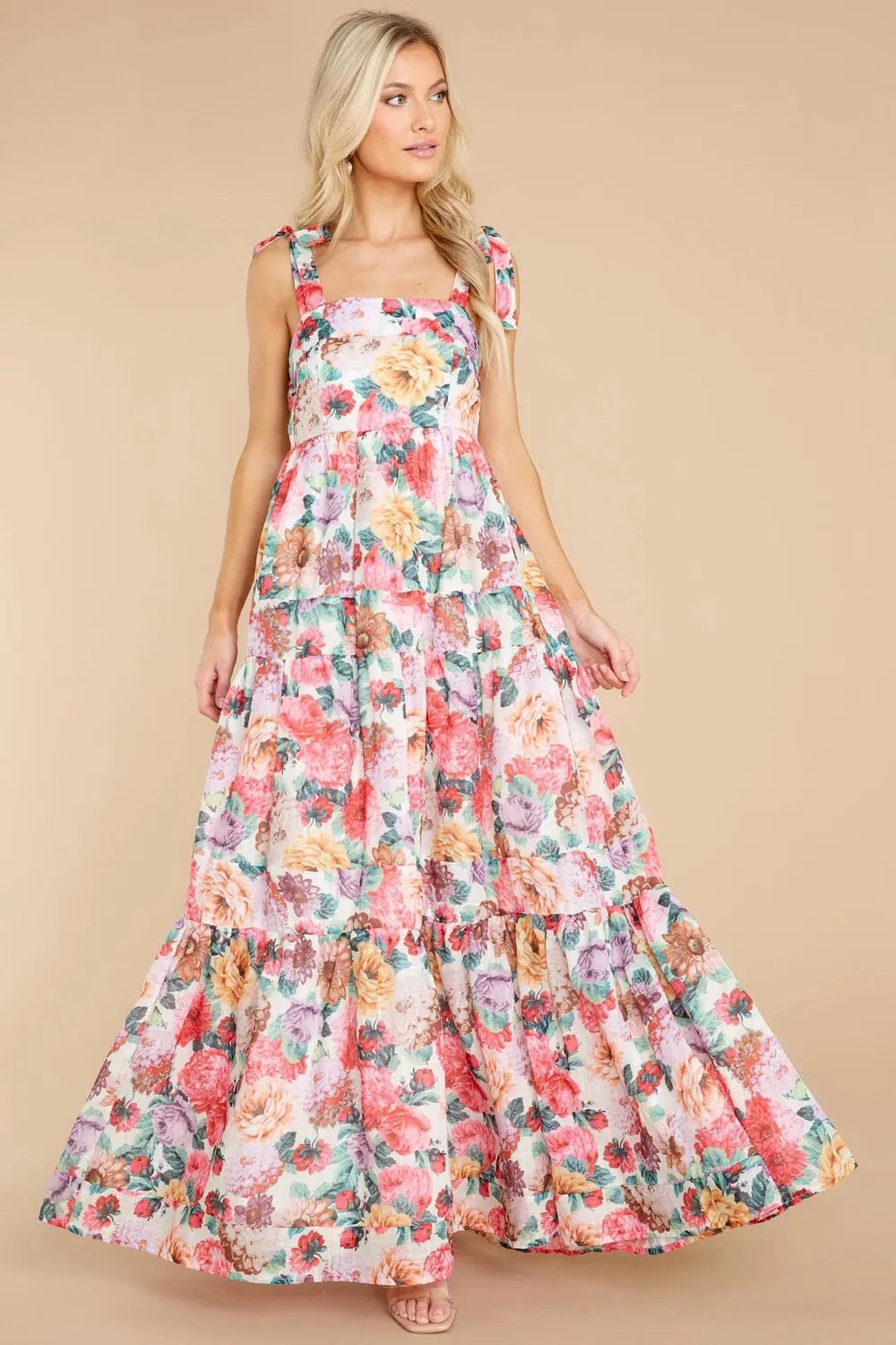A floral square neck maxi dress with tie sleeves and a tiered skirt.