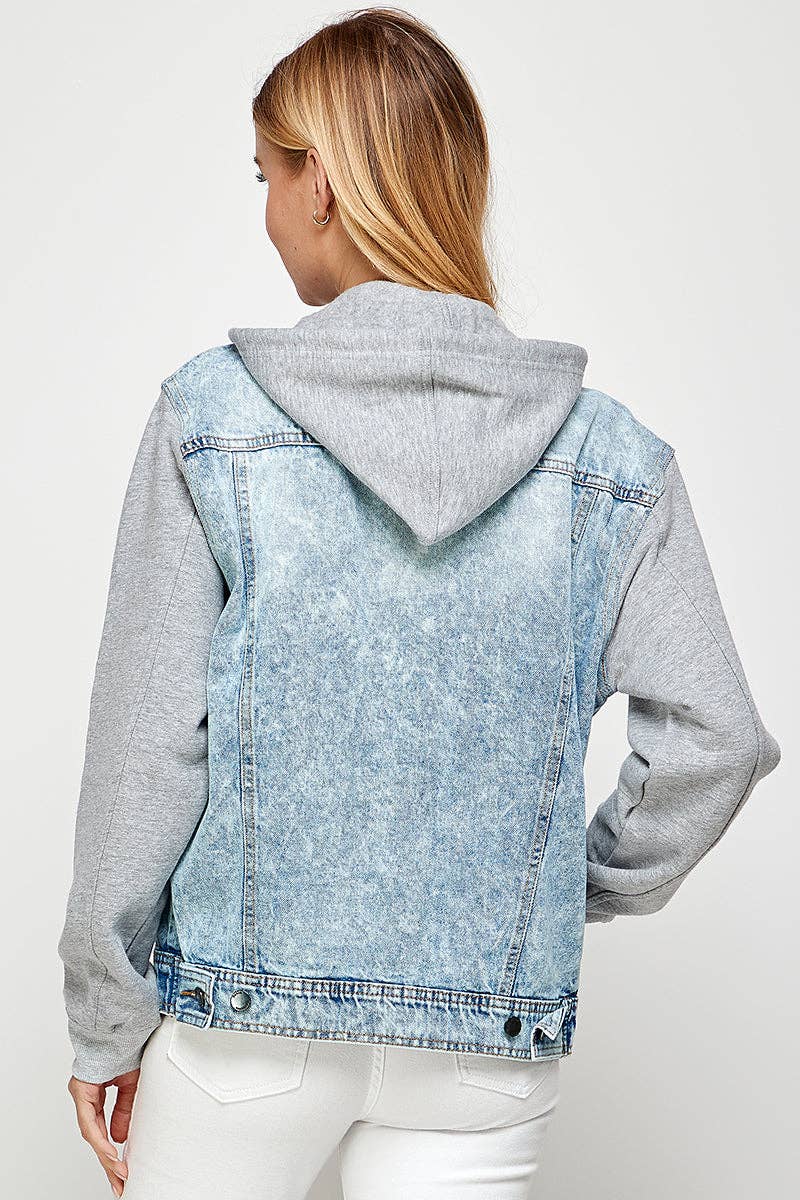 Person wearing a denim jacket with a gray hoodie on a white background