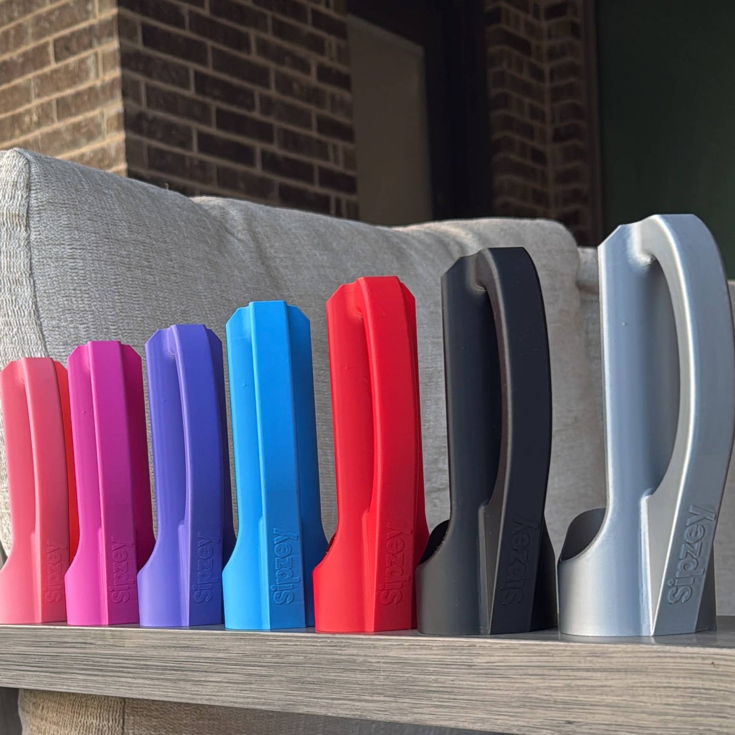 seven sipsy can holders lined up in various colors