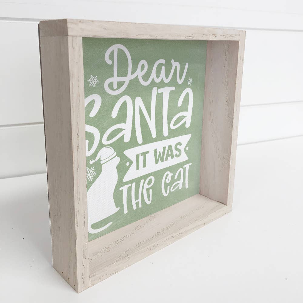 Wooden sign with 'Dear Santa, it was the cat' text on a green background