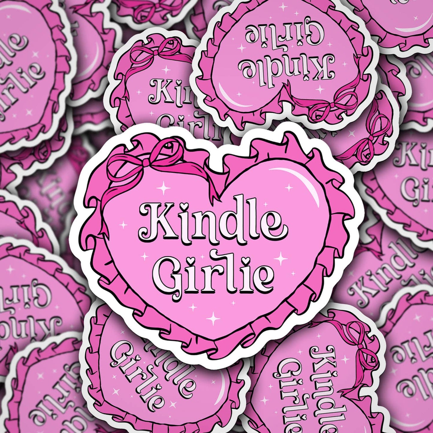 A collection of pink vinyl decals with the text 'Kindle Girlie' arranged in a heart shape pattern.