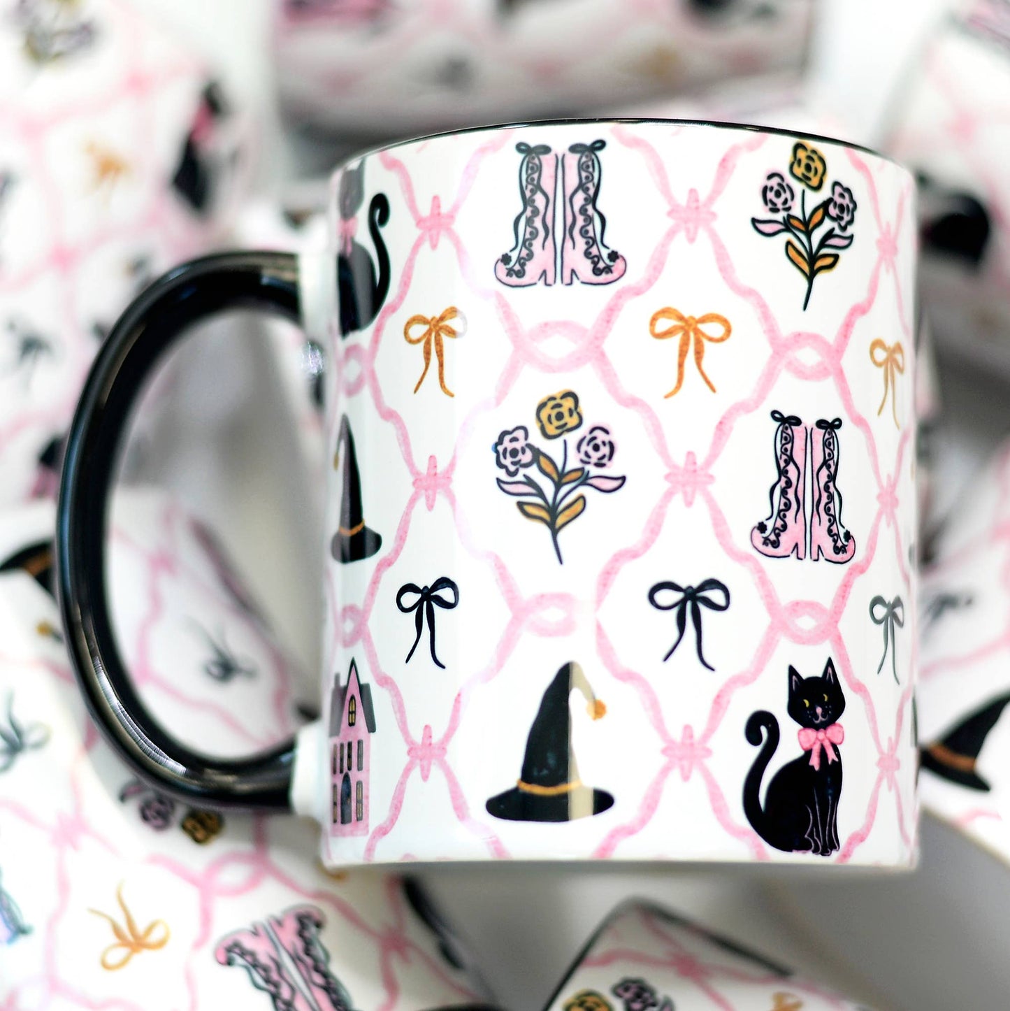 Mug with black cat, witch hat, and floral pattern on a pink background