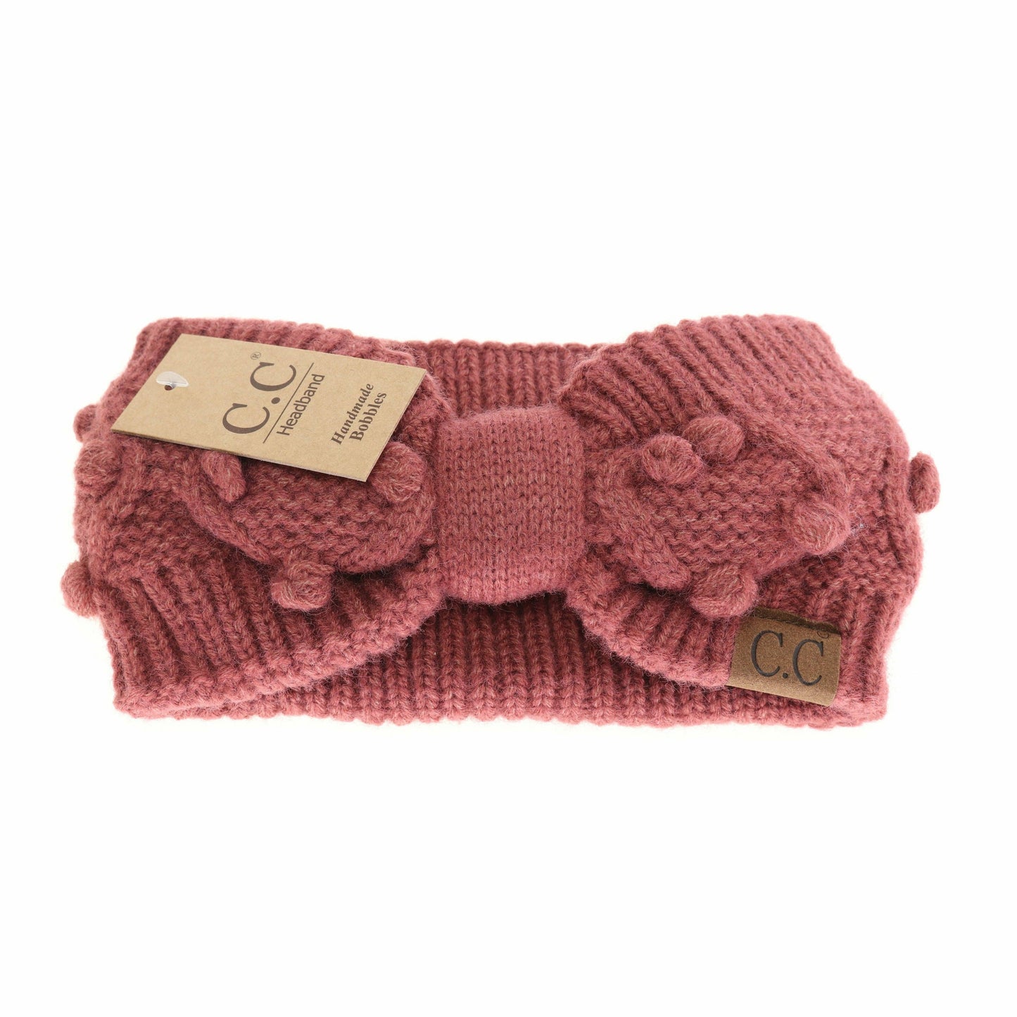 Pink knitted headband with a bow and C.C tag on a white background