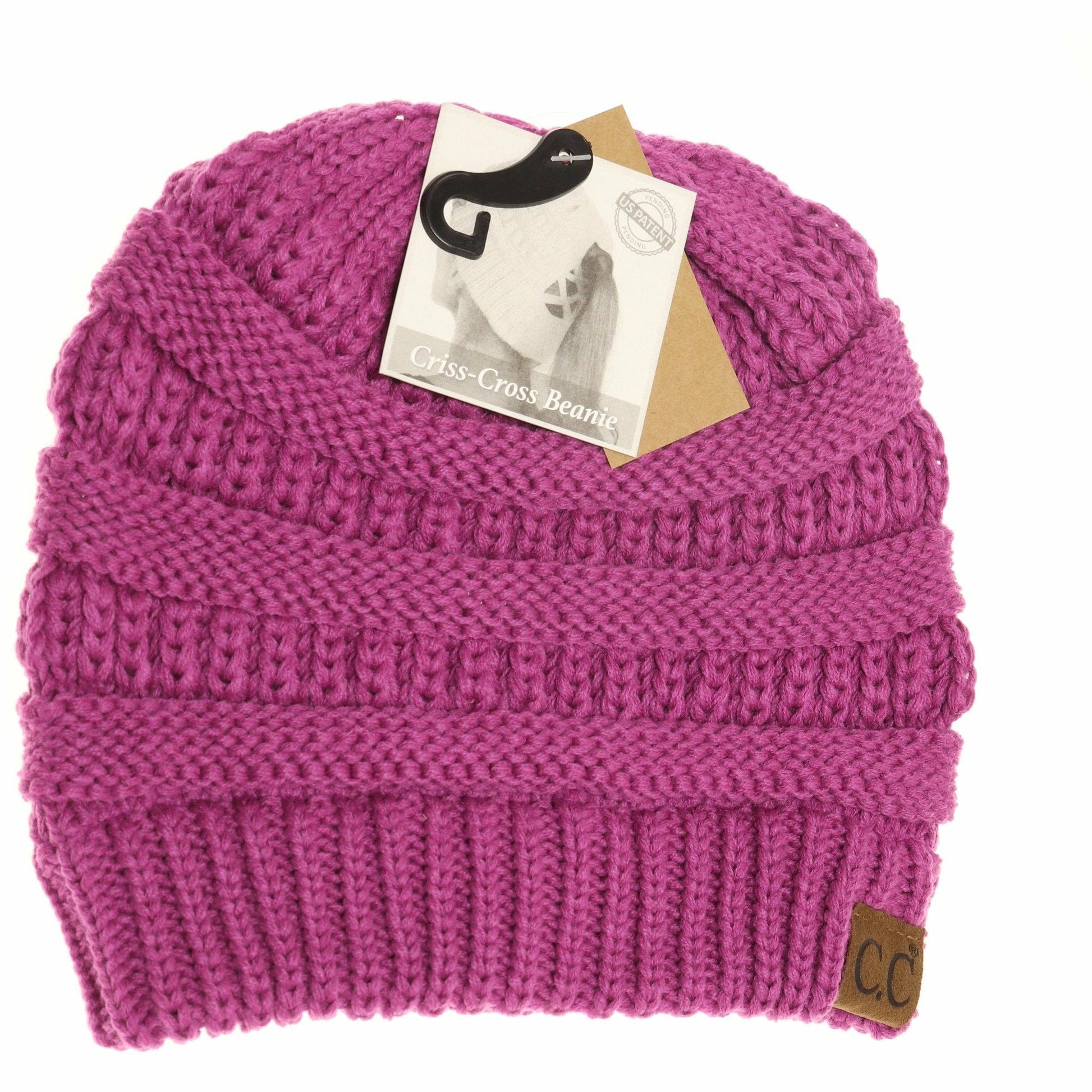 Pink knit beanie with a brand tag on a white background