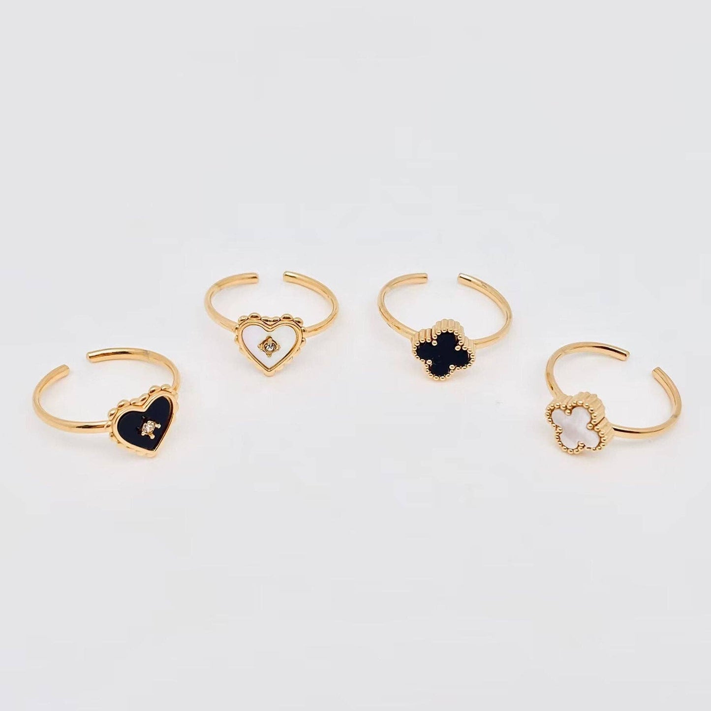 Set of gold rings with black gemstones on a light gray background