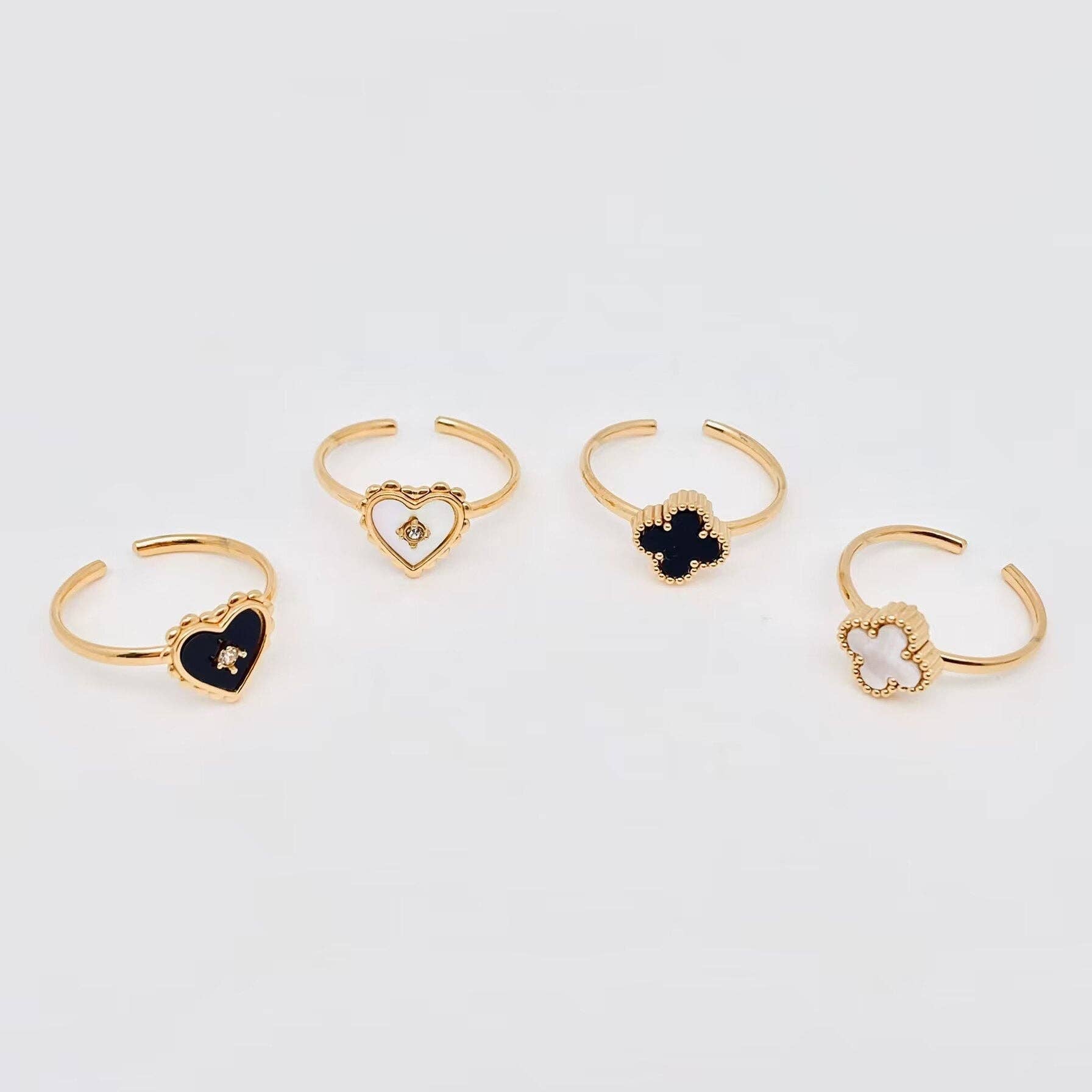 Set of gold rings with black gemstones on a light gray background