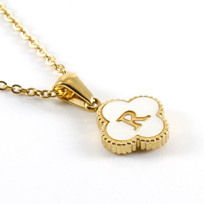 Gold necklace with a clover-shaped pendant featuring the letter 'R' on a white background