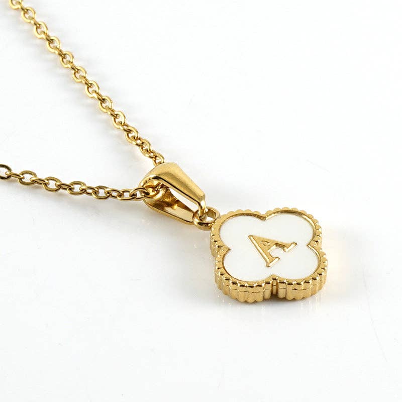 Gold necklace with a clover-shaped pendant featuring the letter 'A' on a white background