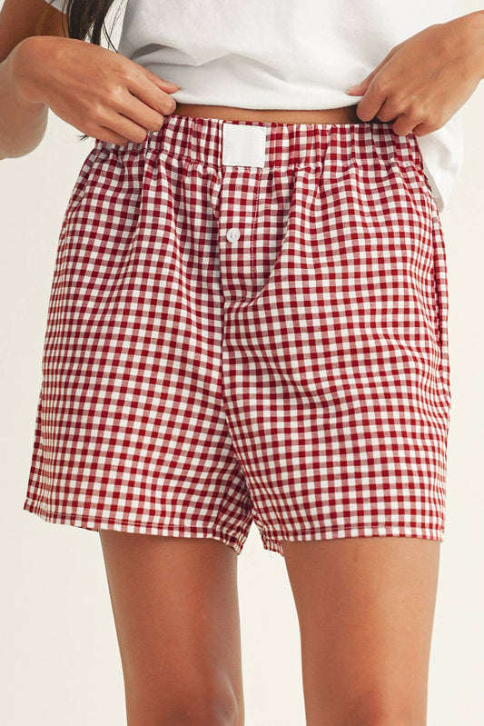 Red and white checkered shorts worn by a person on a plain background