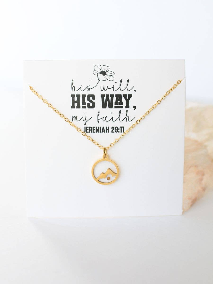 Gold necklace with a circular pendant on a card with text, on a white background