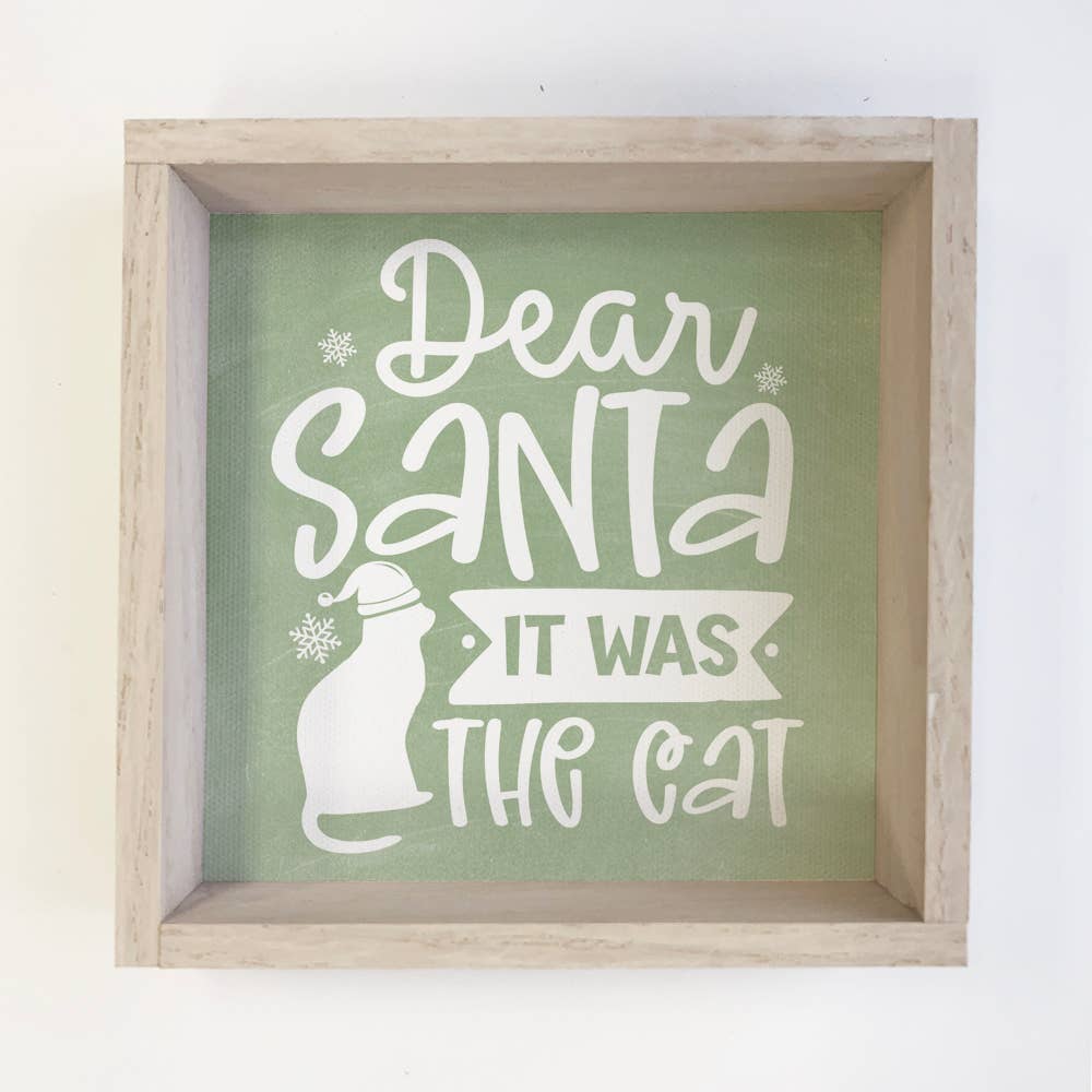 Framed sign with 'Dear Santa It Was The Cat' text on a green background