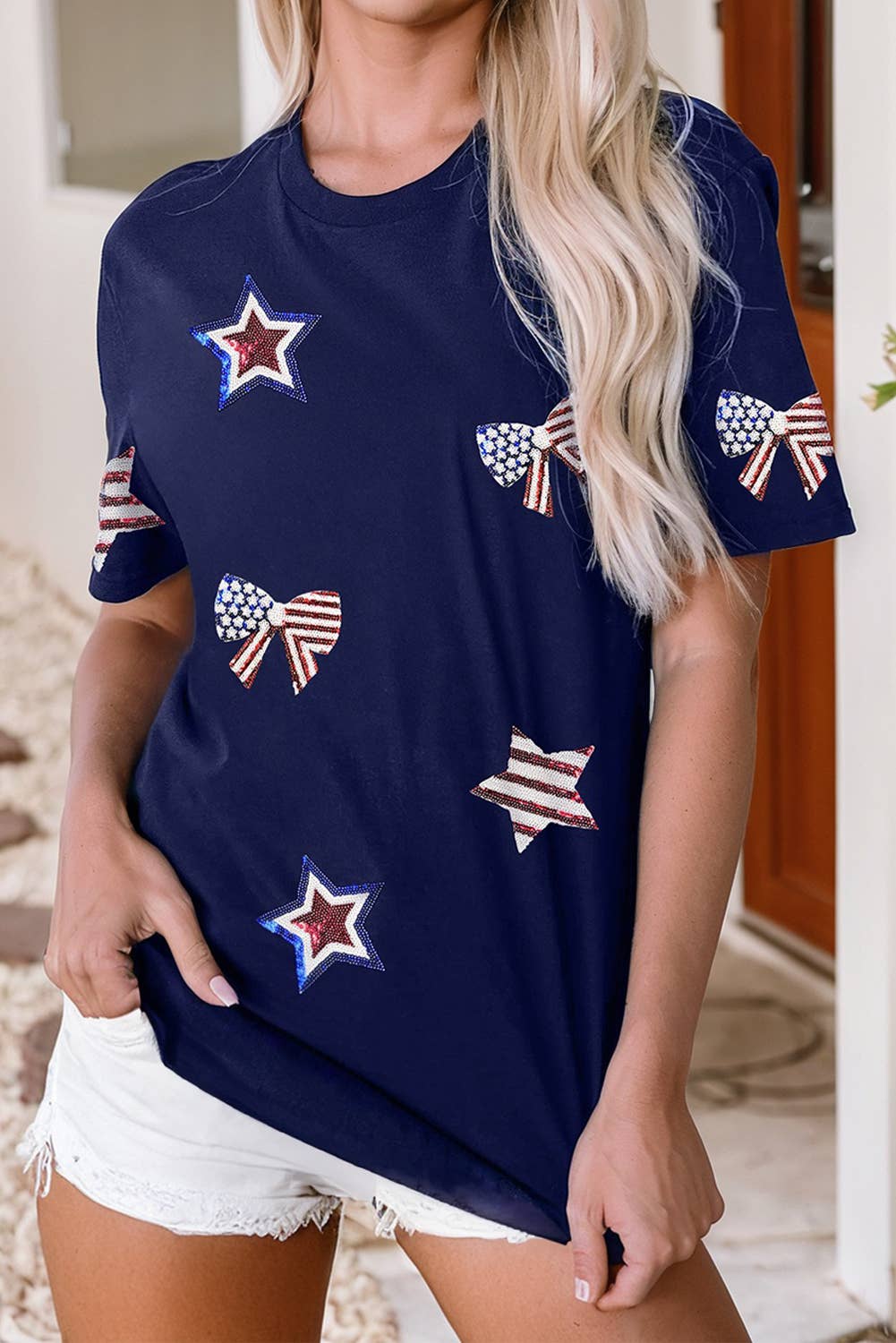 Navy blue t-shirt with star and flag patterns worn by a person.