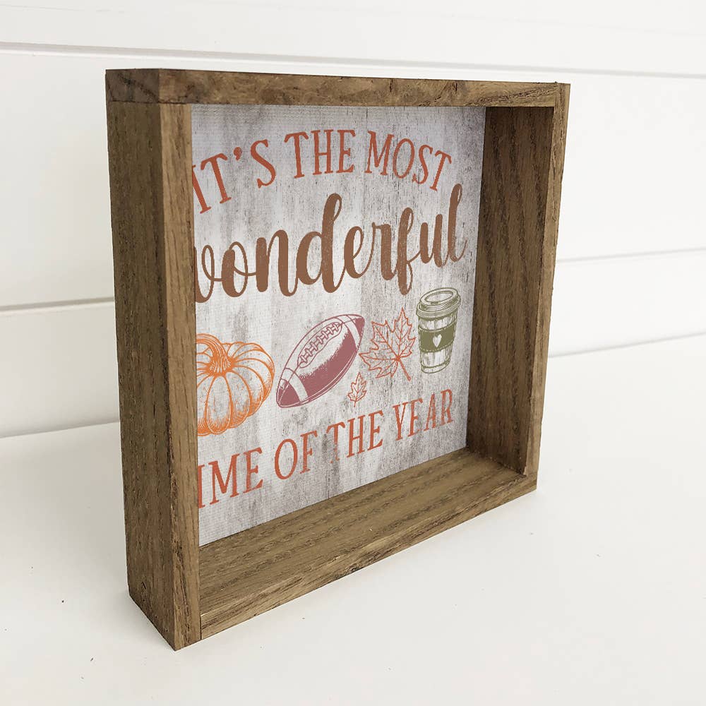 Decorative sign with autumn-themed text and graphics in a wooden frame.
