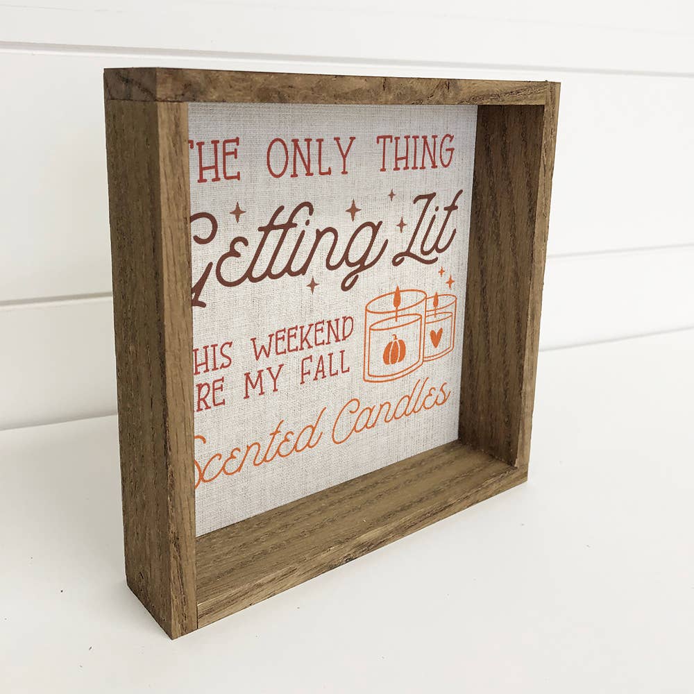 Wooden framed sign with text about fall scented candles on a white background