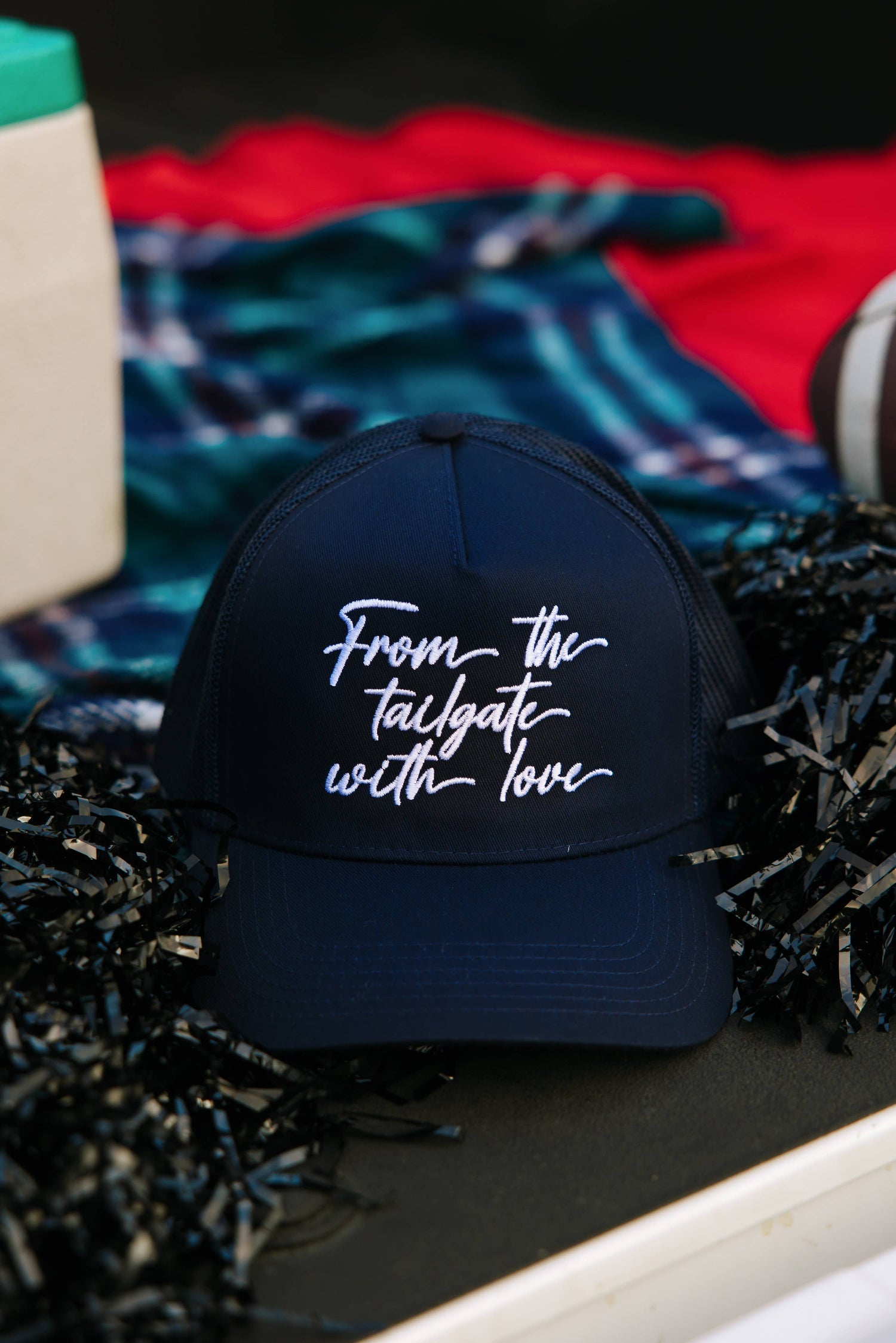A navy baseball cap with mesh back featuring white embroidered text 'From The Tailgate With Love' 