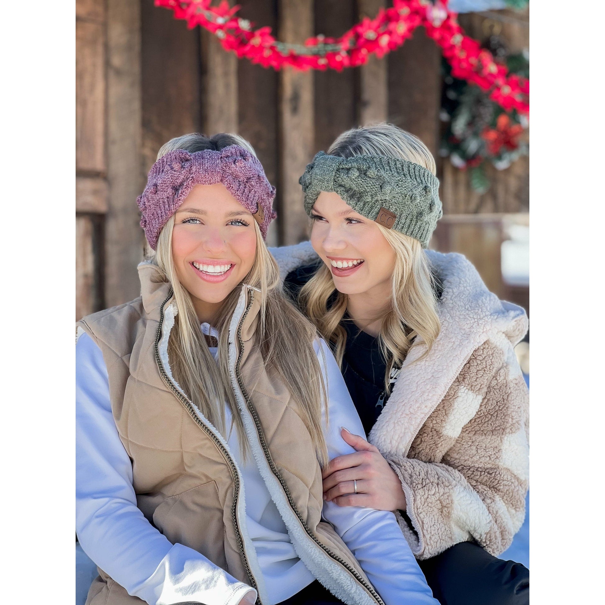 Two women wearing knitted headbands in a snowy outdoor setting.