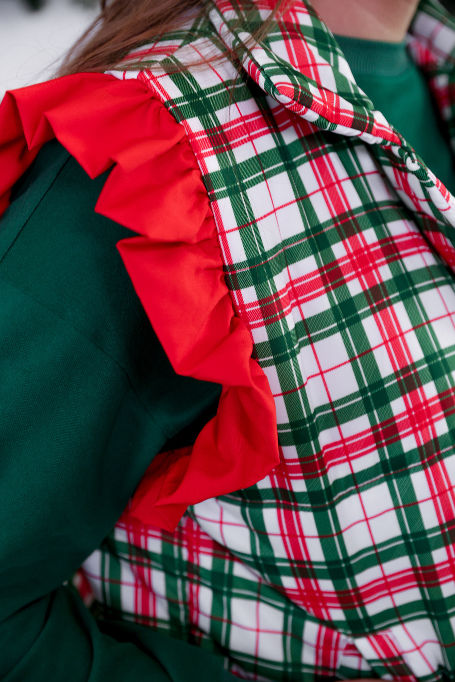 Close-up of a green garment with red and white plaid trim