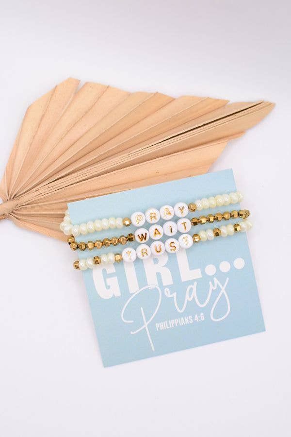 Set of beaded bracelets on a card with text, accompanied by dried leaves on a light background