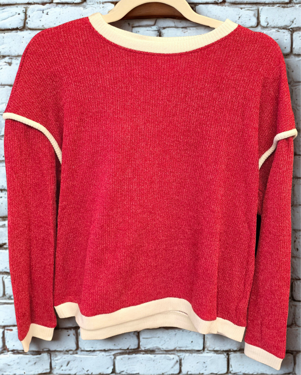 Red sweatshirt against a brick background