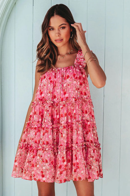 This image features a vibrant, wide strap floral mini dress. The dress is adorned with a lively pink floral pattern, creating a cheerful and youthful look.