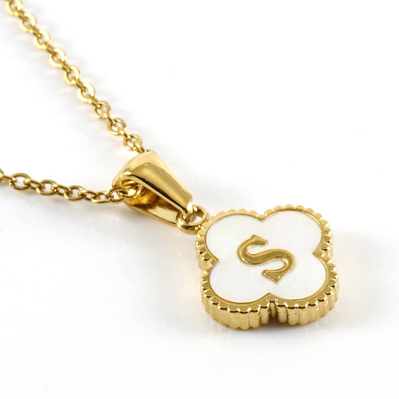 Gold necklace with a clover-shaped pendant featuring the letter 'S' on a white background