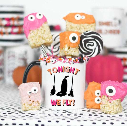 Halloween-themed treats with a mug labeled 'TONIGHT WE FLY!' on a decorative surface.