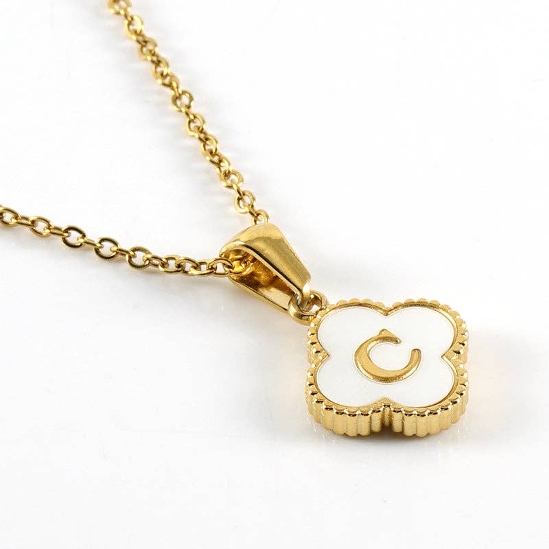 Gold necklace with a heart-shaped pendant featuring the letter 'C' on a white background