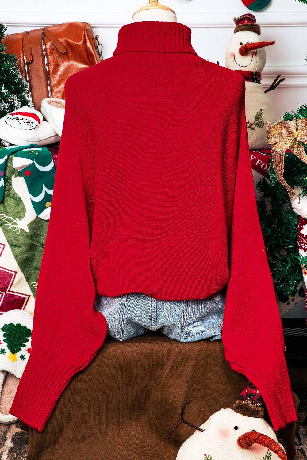 Red sweater on a mannequin with Christmas decorations in the background