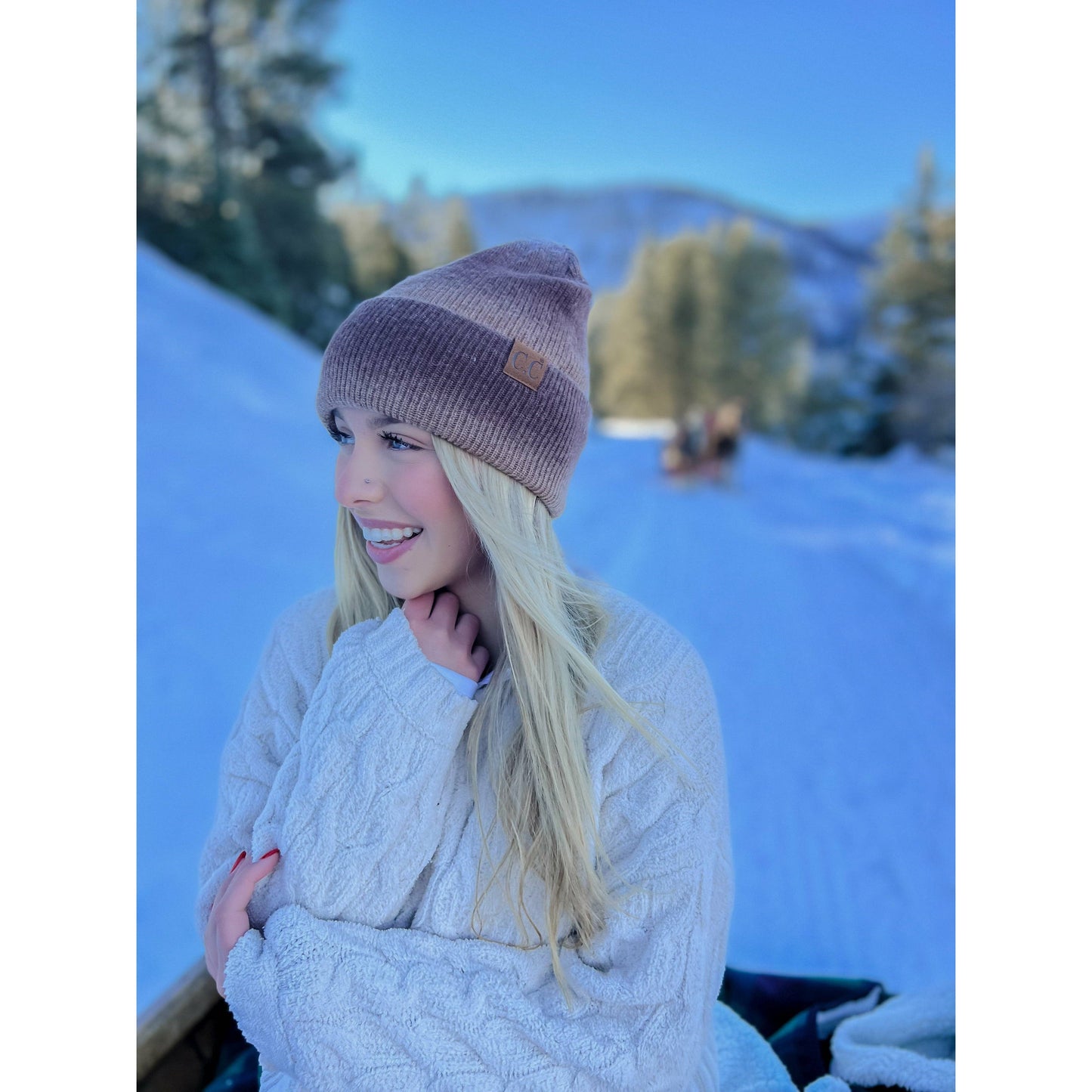 Person wearing a knit hat and sweater in a snowy landscape