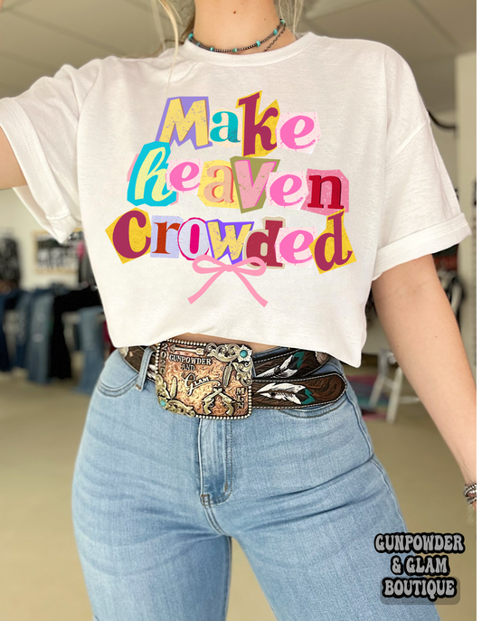 Person wearing a white t-shirt with colorful text and jeans indoors.