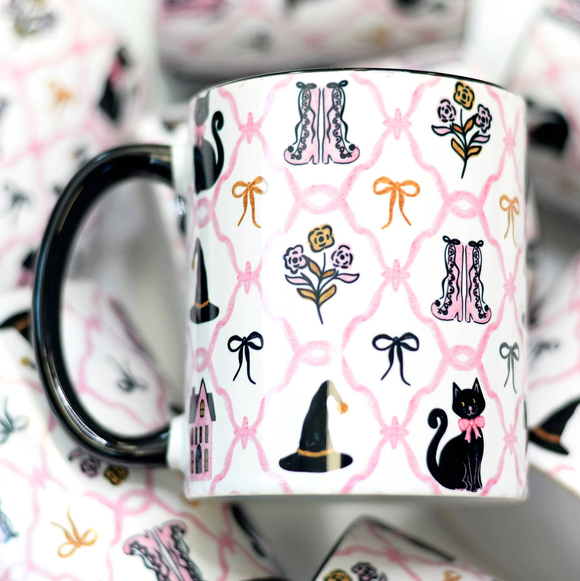 Mug with black cat, witch hat, and floral pattern on a pink background