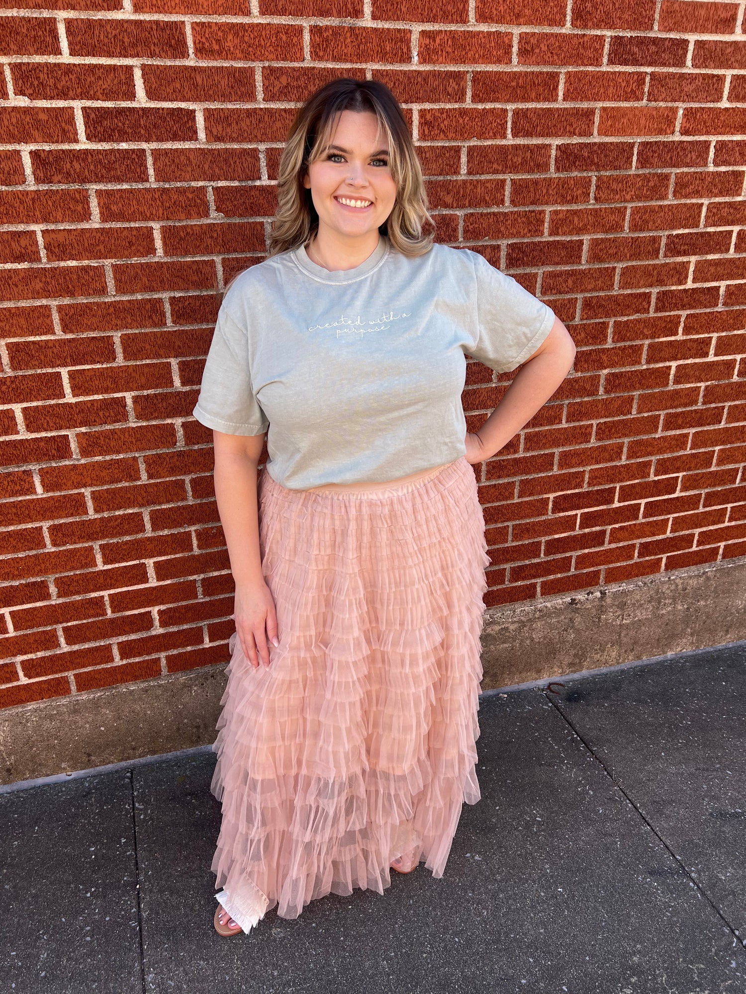 This image features a stylish elastic waist ruffle tulle maxi skirt in a soft blush pink color. The skirt extends to a full length, providing an elegant flow and fit.